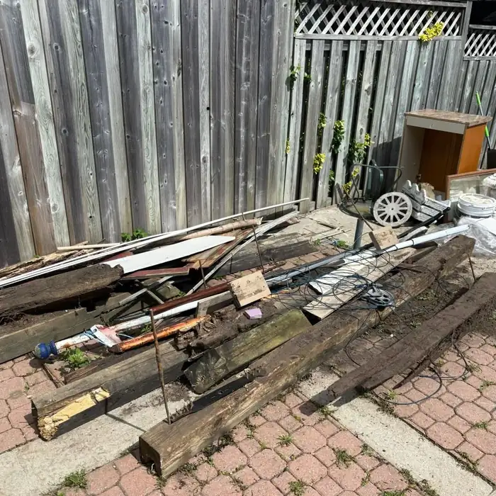 Patio and fence line before BK Junk Co. cleared old lumber and debris